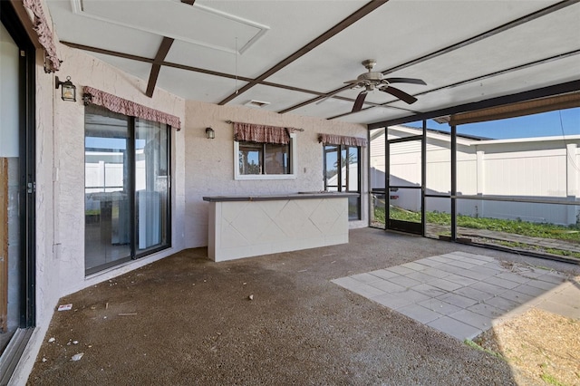 unfurnished sunroom with ceiling fan