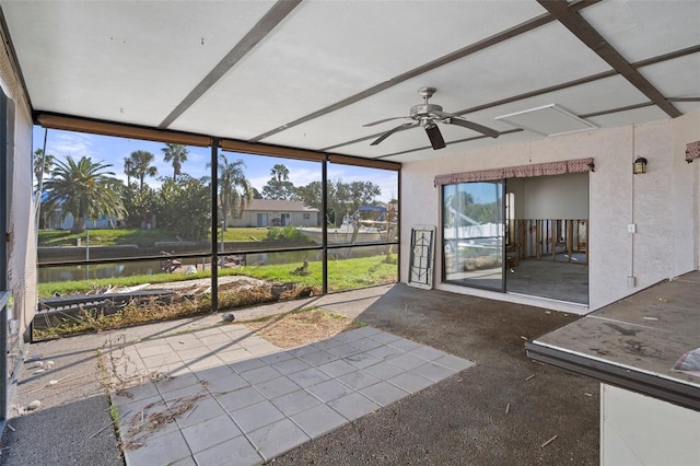 unfurnished sunroom featuring ceiling fan, a water view, and a wealth of natural light