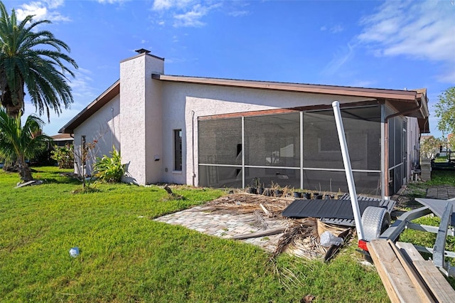 back of property featuring a sunroom and a yard