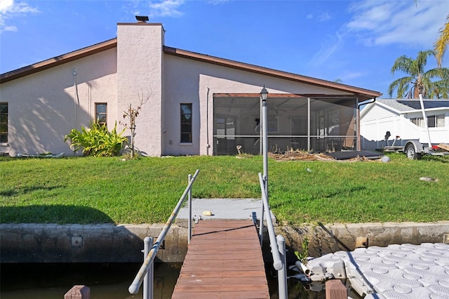 back of house featuring a yard and a sunroom