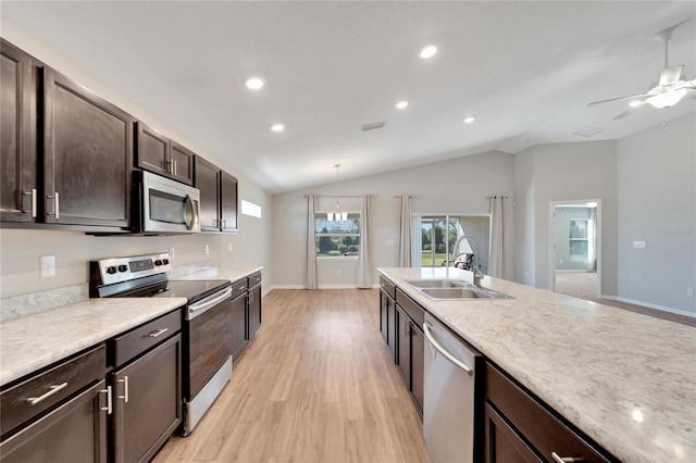 kitchen with light hardwood / wood-style floors, sink, stainless steel appliances, and vaulted ceiling