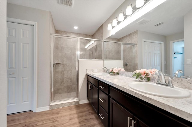 bathroom with hardwood / wood-style floors, vanity, and an enclosed shower