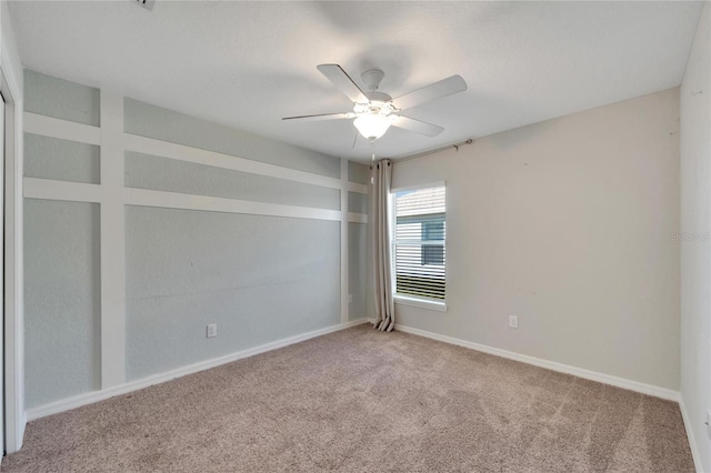 carpeted spare room featuring ceiling fan