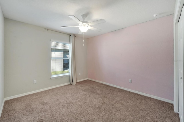 carpeted spare room featuring ceiling fan