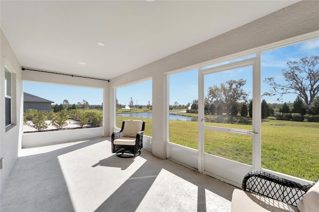 sunroom with plenty of natural light and a water view