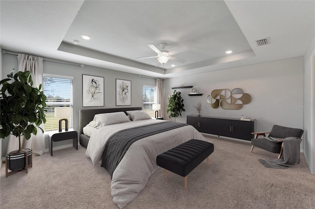 bedroom with a tray ceiling, multiple windows, and ceiling fan