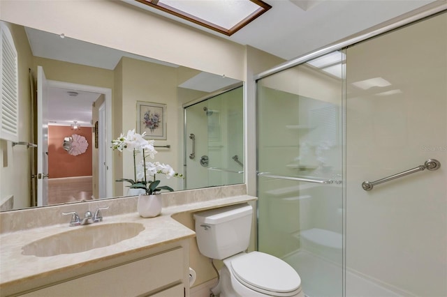 bathroom with vanity, a shower with shower door, and toilet