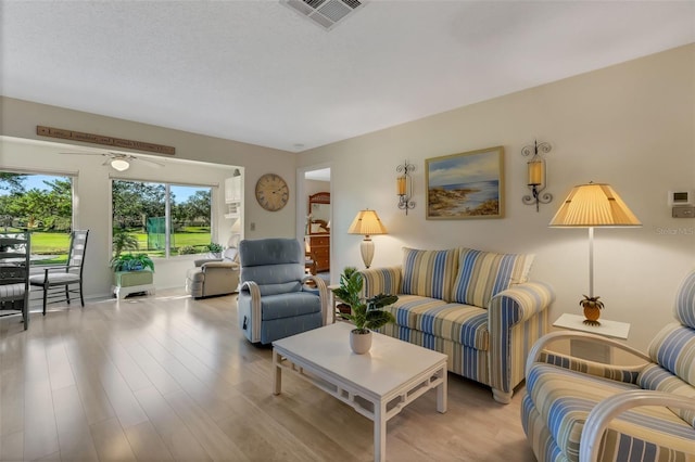 living room with light wood-type flooring and ceiling fan