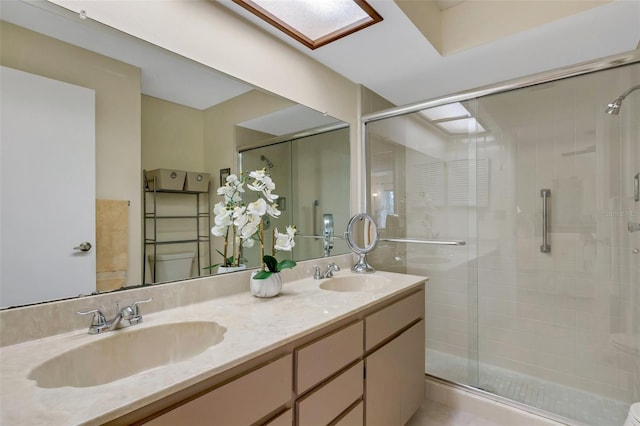 bathroom featuring vanity, a skylight, toilet, and an enclosed shower