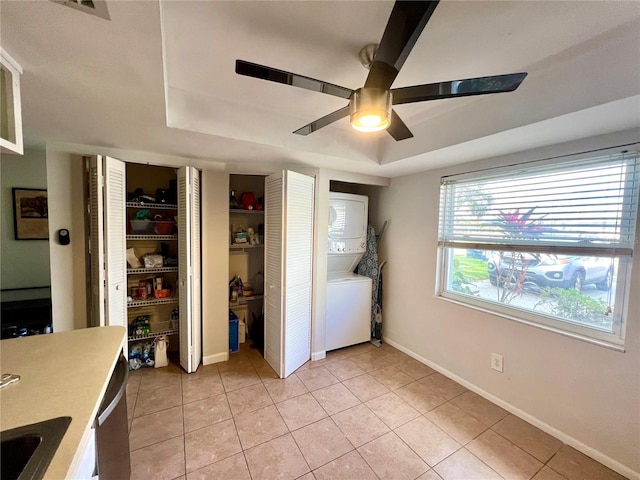 interior space with ceiling fan, light tile patterned floors, and stacked washer and dryer