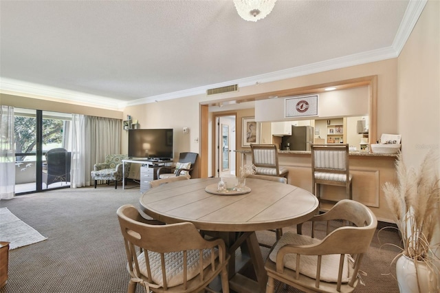 dining room featuring carpet flooring, a textured ceiling, and crown molding