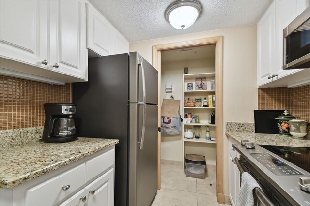 36750 US Highway 19 N Unit 19219, Palm Harbor, FL 34684 - kitchen with appliances with stainless steel finishes, white cabinets, backsplash, and a textured ceiling