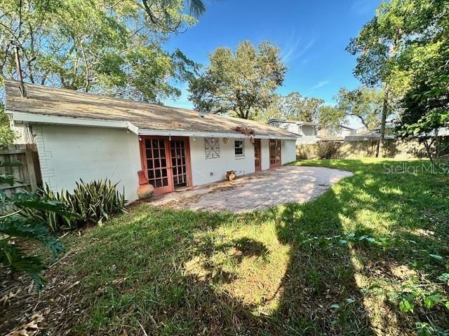 rear view of house with a lawn and a patio area