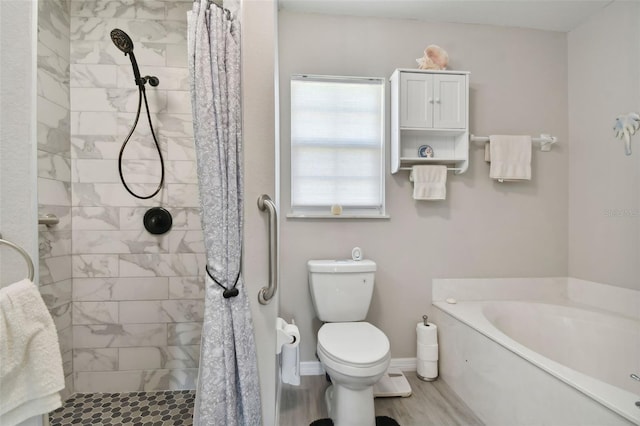 bathroom with a garden tub, toilet, wood finished floors, and a tile shower