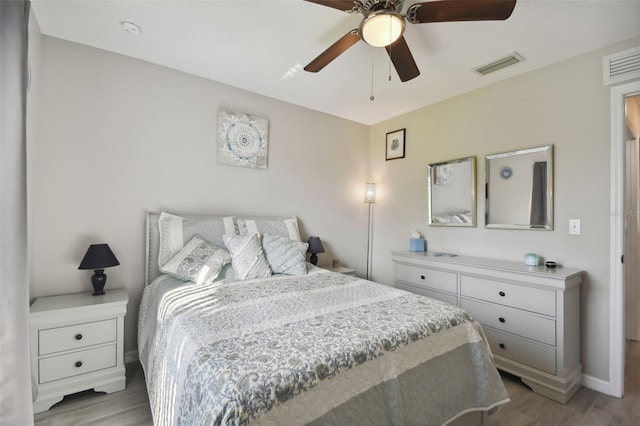 bedroom featuring a ceiling fan, wood finished floors, and visible vents