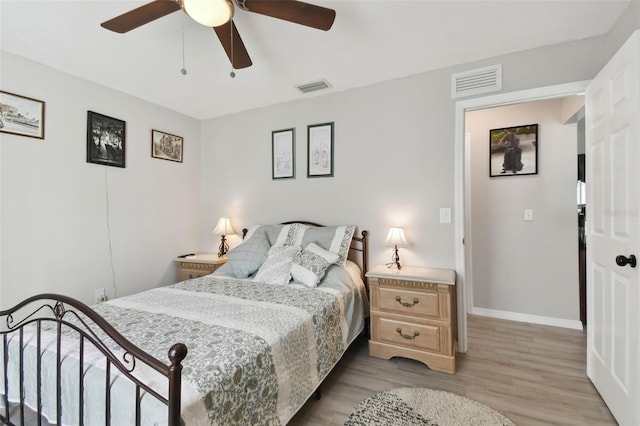 bedroom with light wood-type flooring, visible vents, baseboards, and a ceiling fan