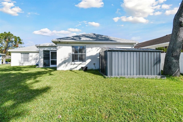 back of house featuring stucco siding and a lawn