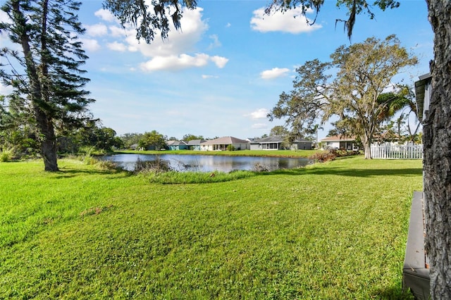 view of yard with fence and a water view