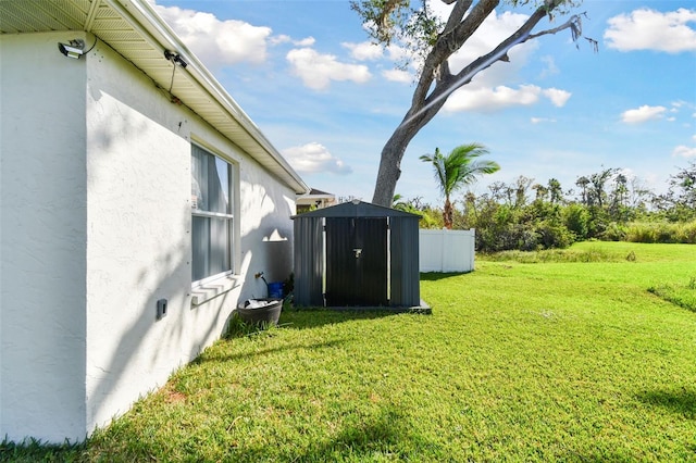 view of yard featuring an outbuilding, a storage shed, and fence