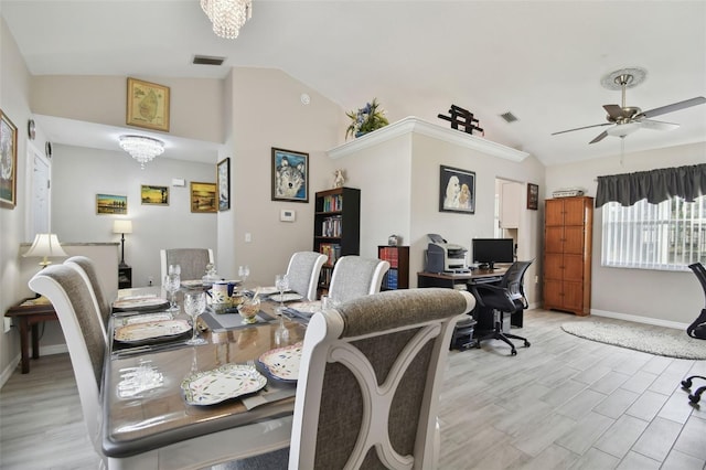 dining room featuring light wood finished floors, visible vents, ceiling fan with notable chandelier, and vaulted ceiling