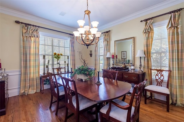 dining space with a chandelier, hardwood / wood-style flooring, and ornamental molding