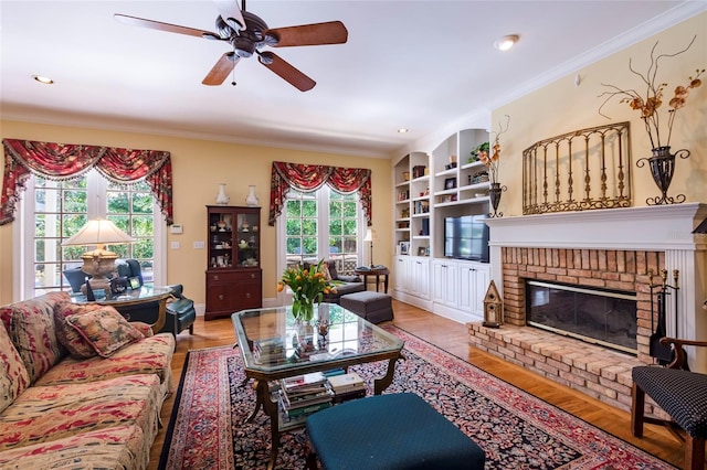 living room with ceiling fan, a fireplace, and light hardwood / wood-style floors