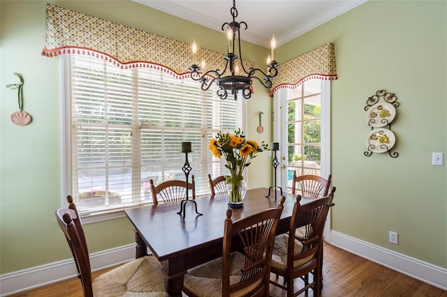 dining space featuring a notable chandelier, wood-type flooring, and crown molding