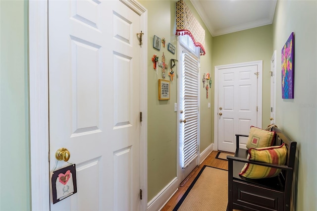 doorway with light hardwood / wood-style floors and ornamental molding