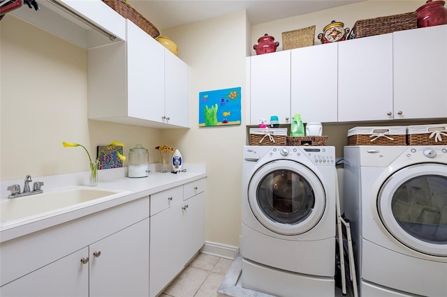 washroom featuring washer and dryer, cabinets, light tile patterned floors, and sink