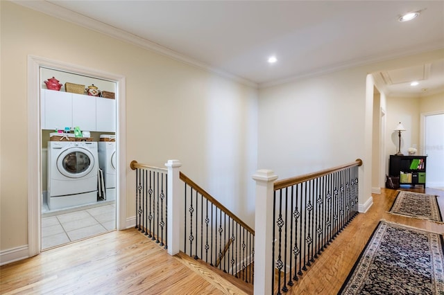 hallway featuring washing machine and dryer, crown molding, and light wood-type flooring