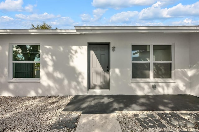 view of exterior entry with a patio area