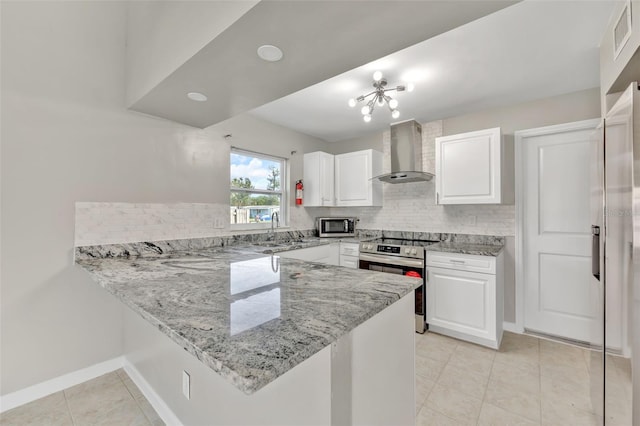 kitchen featuring kitchen peninsula, appliances with stainless steel finishes, light stone countertops, wall chimney range hood, and white cabinetry