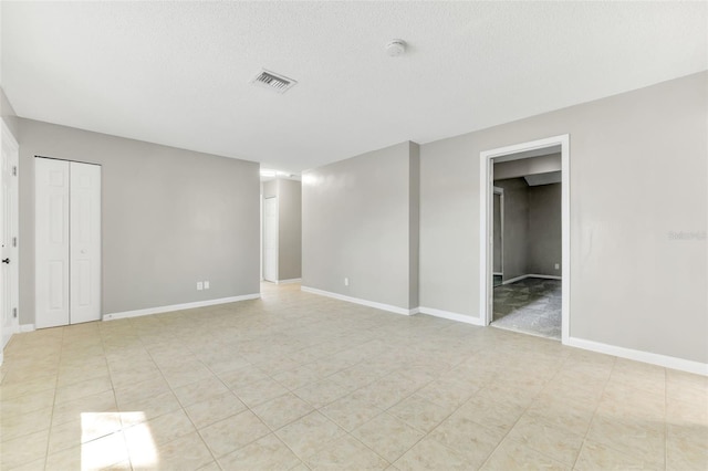 unfurnished room featuring a textured ceiling