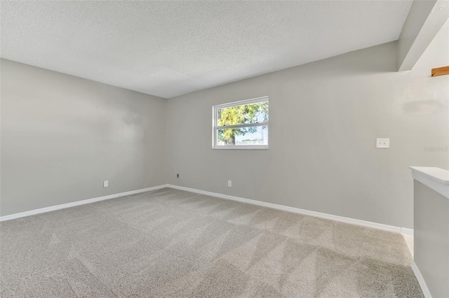 carpeted empty room featuring a textured ceiling