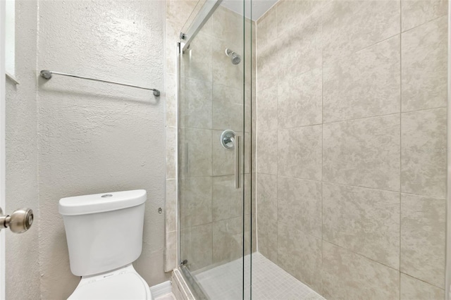 bathroom featuring walk in shower and toilet