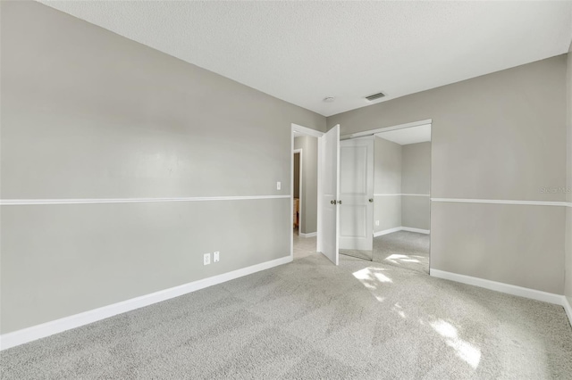 unfurnished bedroom featuring carpet flooring, a textured ceiling, and a closet