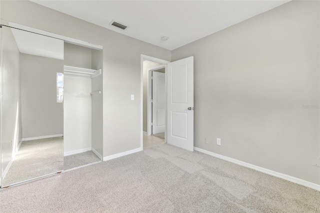 unfurnished bedroom with light carpet and a closet