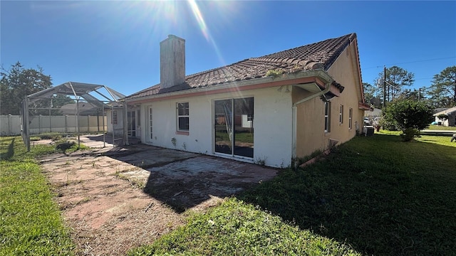 back of house with a yard, a patio, and a lanai