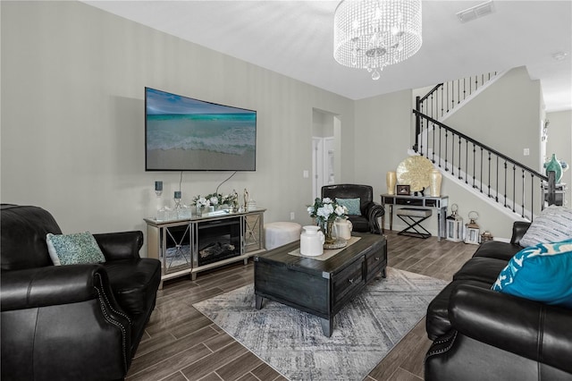 living room featuring dark hardwood / wood-style floors and an inviting chandelier