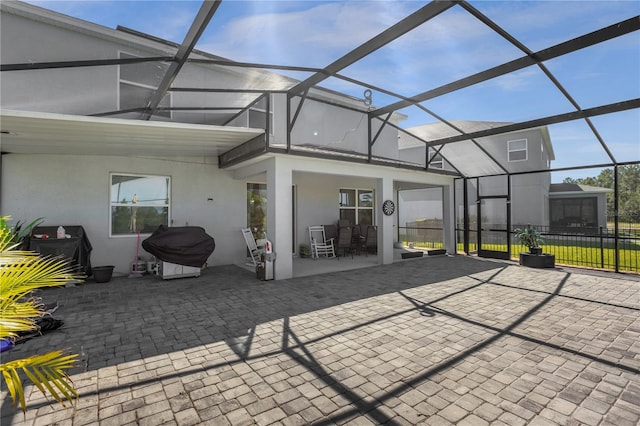 rear view of house with glass enclosure and a patio area