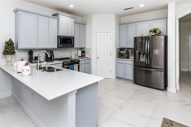 kitchen with a kitchen breakfast bar, kitchen peninsula, sink, and appliances with stainless steel finishes