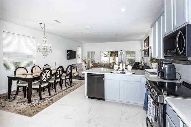 kitchen featuring kitchen peninsula, sink, black appliances, decorative light fixtures, and a chandelier