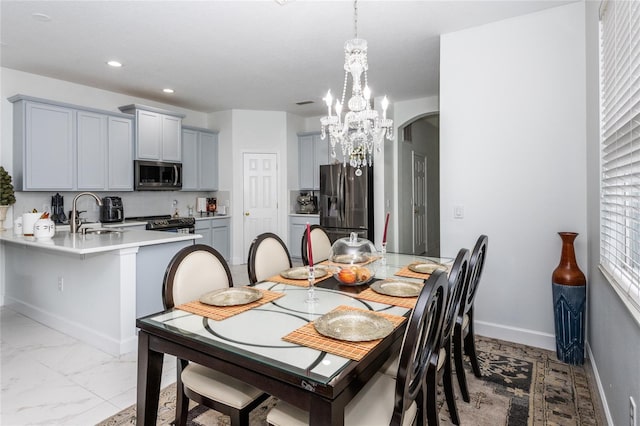 dining room with an inviting chandelier, a healthy amount of sunlight, and sink