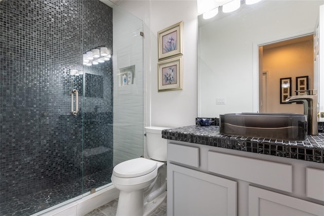 bathroom with tile patterned floors, vanity, toilet, and an enclosed shower