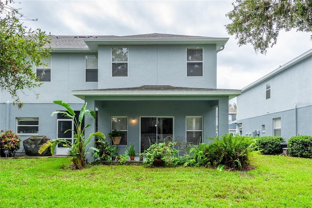 rear view of house featuring a lawn