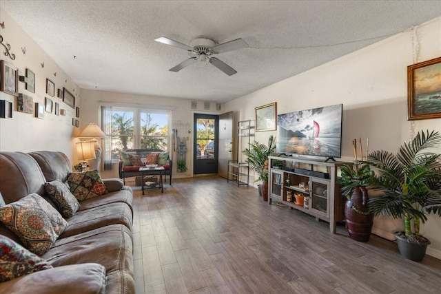 living room with ceiling fan, a textured ceiling, and hardwood / wood-style flooring