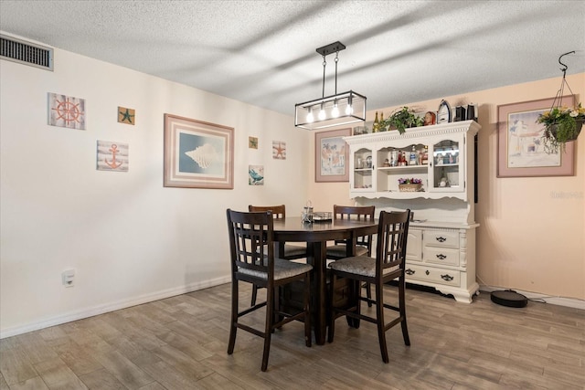 dining room featuring hardwood / wood-style floors and a textured ceiling