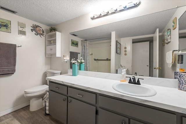 bathroom with hardwood / wood-style floors, a textured ceiling, toilet, vanity, and a shower with shower curtain