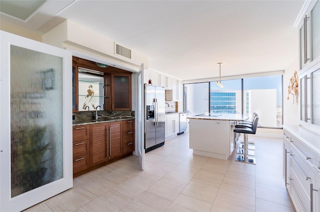 kitchen with white cabinets, tasteful backsplash, a kitchen island, a kitchen bar, and stainless steel appliances