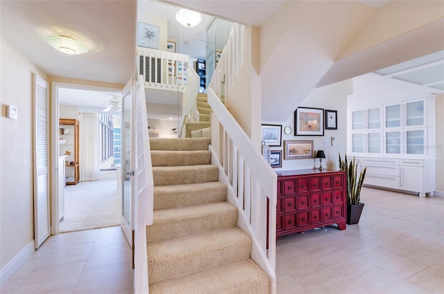 staircase with a towering ceiling and carpet floors